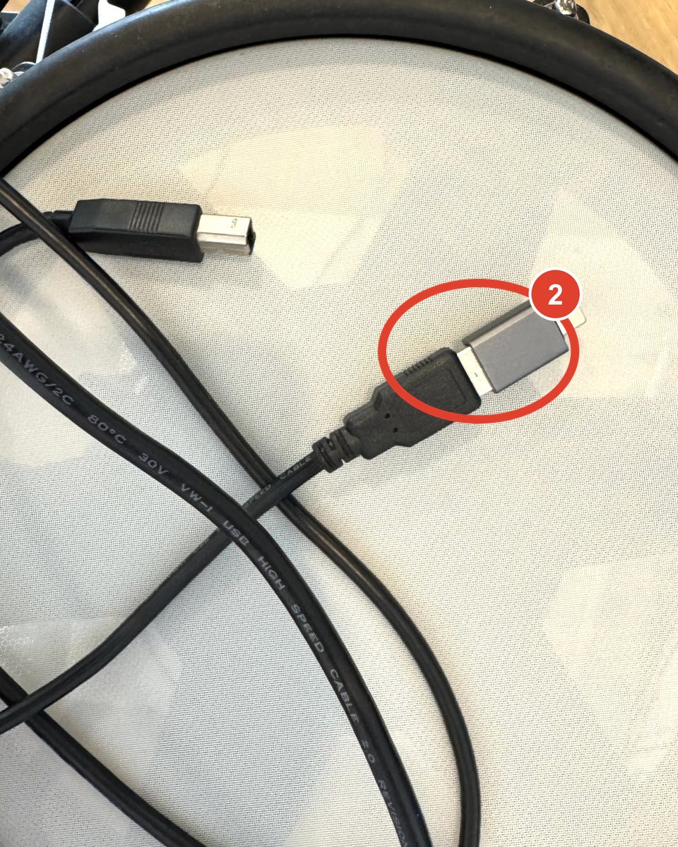The USB-A plug of the kit cable inserted into a small grey USB-C to USB-A adapter.