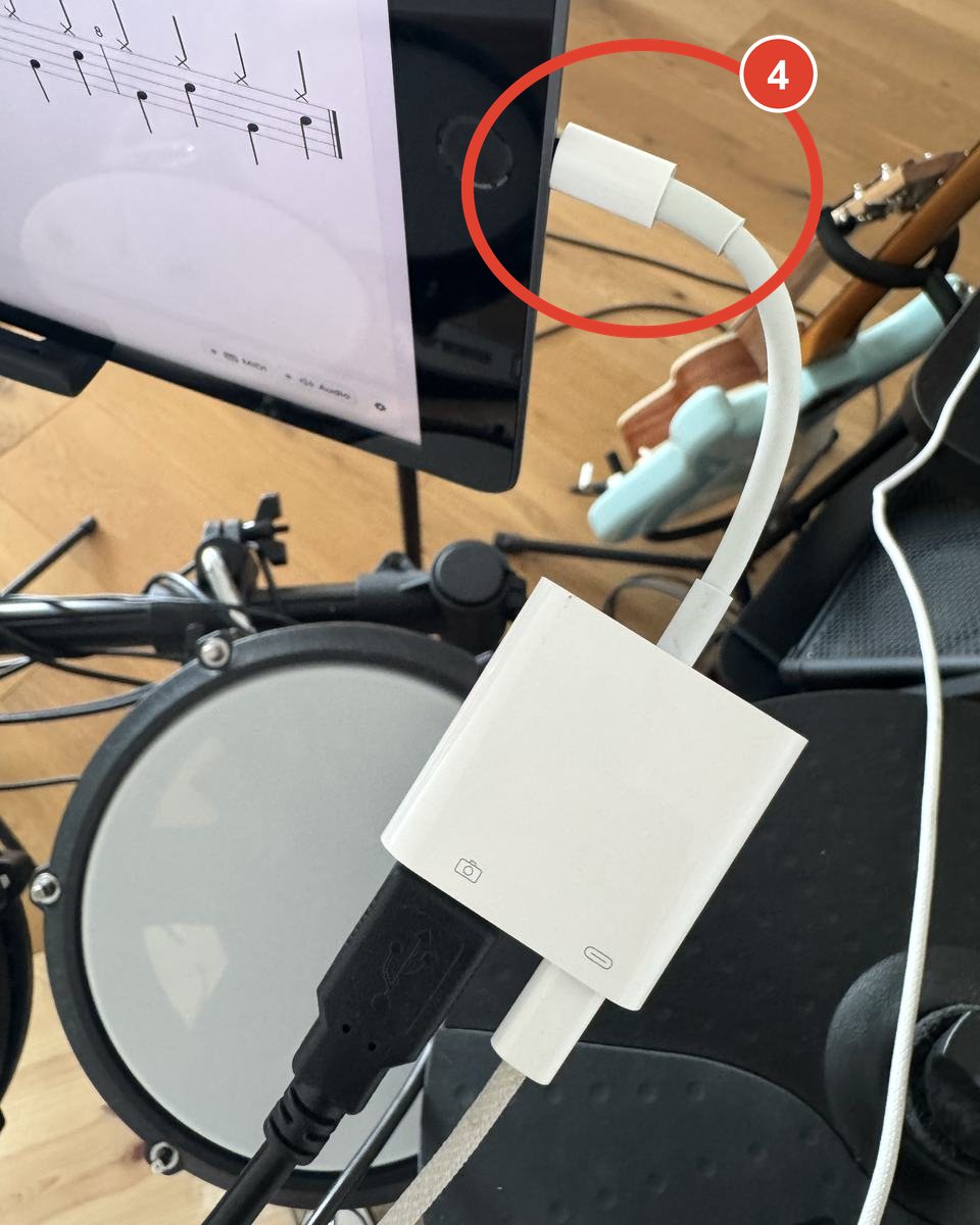 The camera adapter plugged into an iPad on a stand, with the kit cable and the charger both connected and iQuantize on screen.